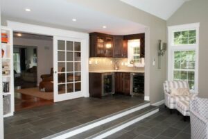 A wet bar with granite, glass tile backsplash and beverage fridges give guests opportunity to serve themselves - in law apartment additions windham nh