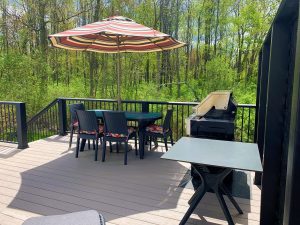 Composite decks in Salem Nh that had been renovated and furnished with a table, chairs, and grill